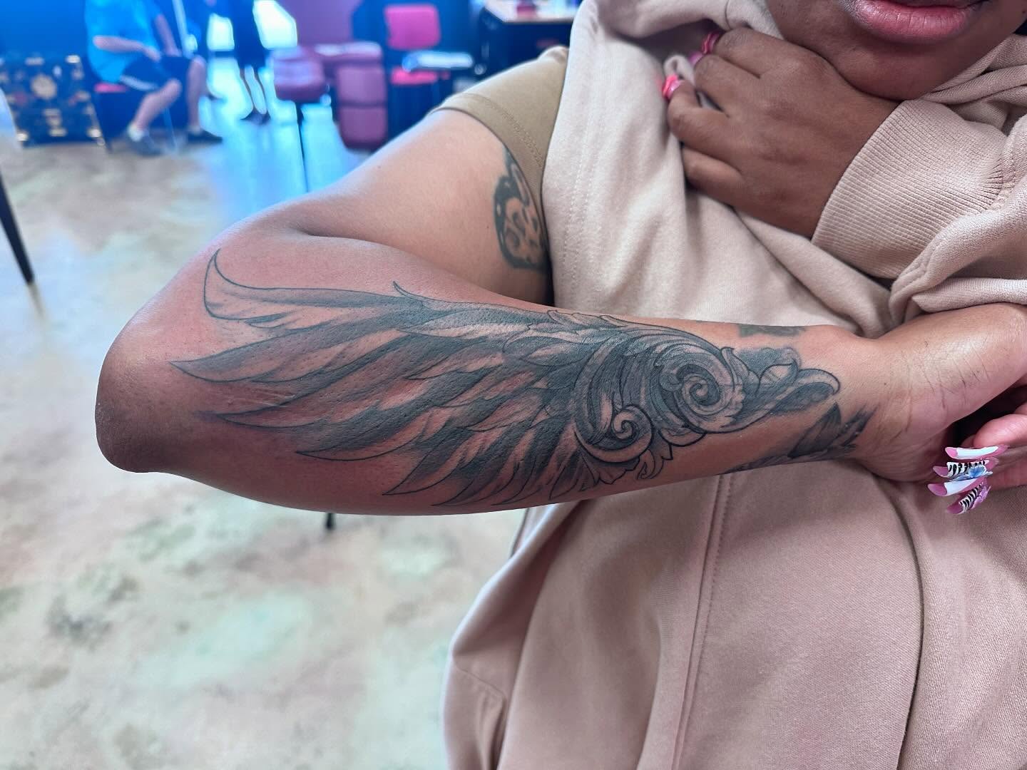 Wing black and grey tattoo on the forearm by Shawn Cook