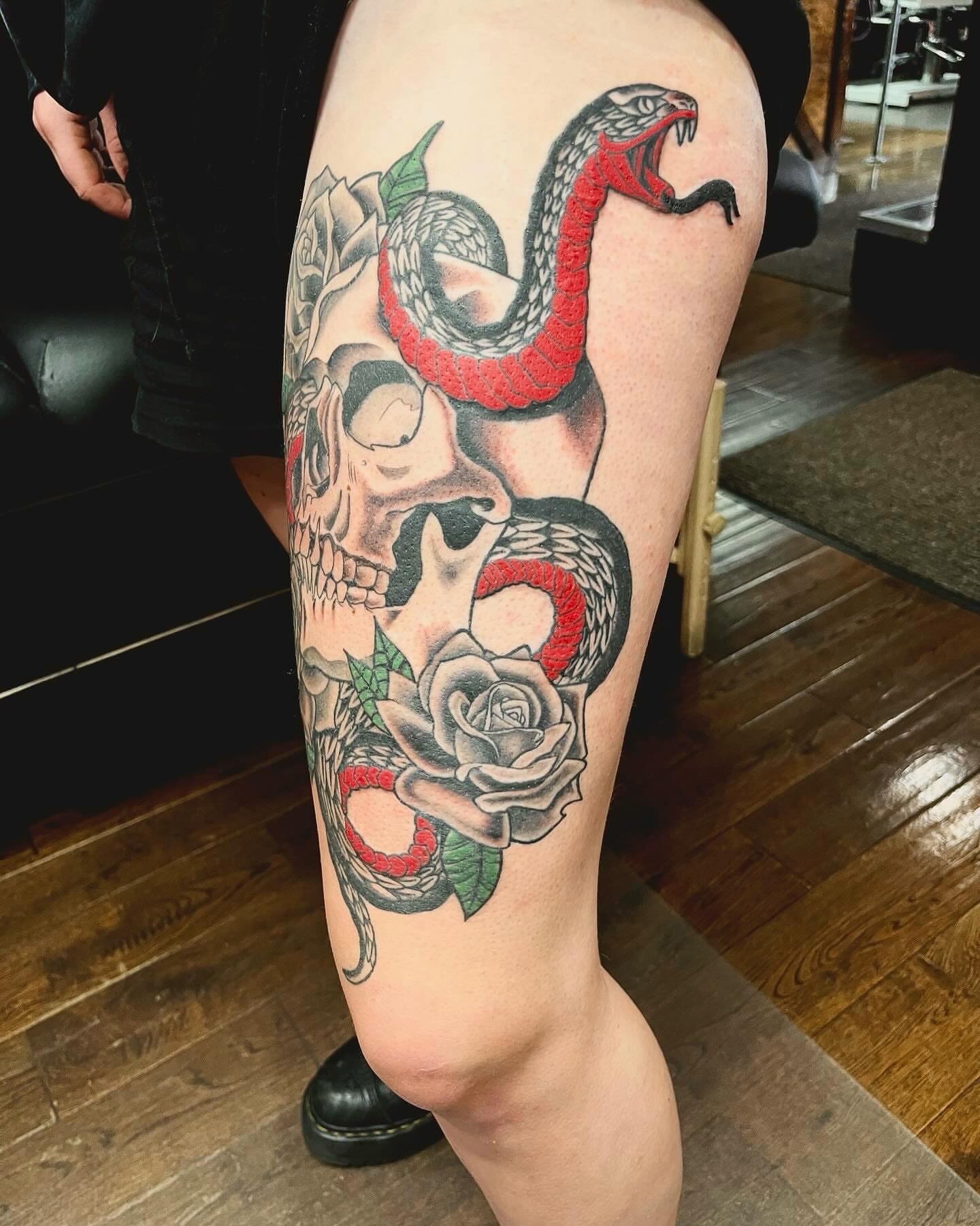 Snake and skull American traditional tattoo on the thigh by Kenny Buck
