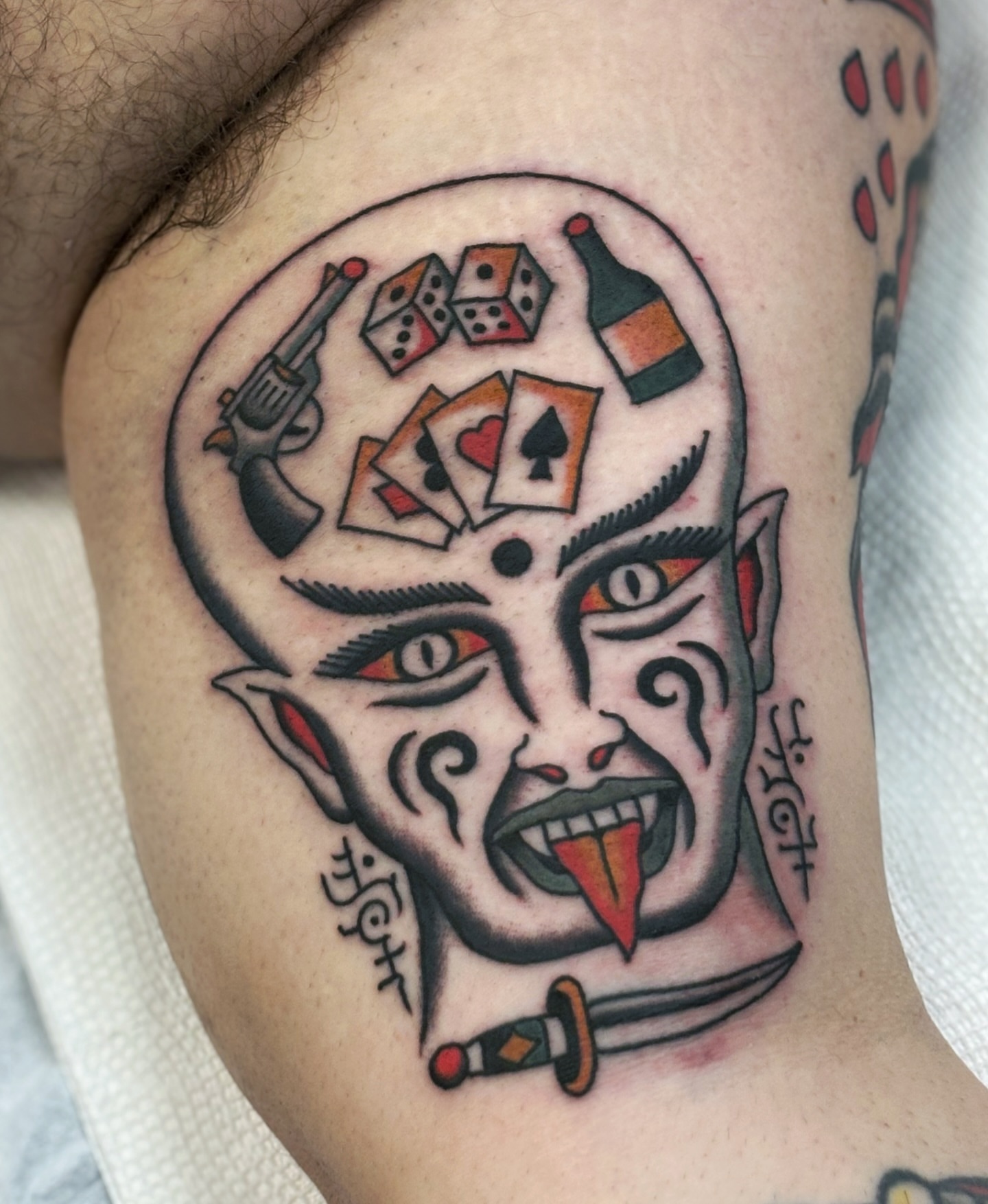 Demon face American traditional tattoo on the thigh by Ben Fiedler