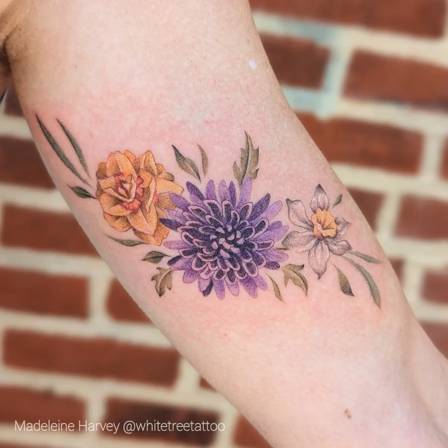 Floral bouquet realism tattoo on the forearm by Maddie