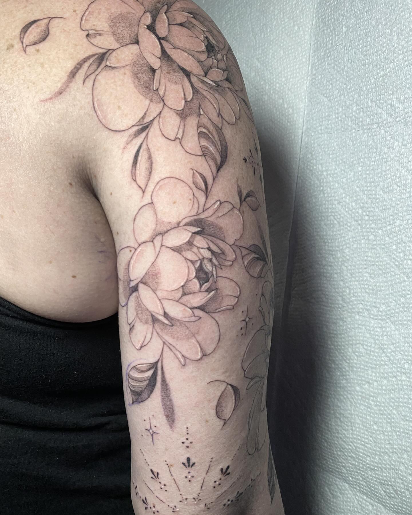 Floral bouquet black and grey tattoo on the upper arm by 𝔈𝔯𝔦𝔫 𝔊𝔦𝔩𝔩𝔦𝔩𝔞𝔫𝔡, Springfield, Ohio