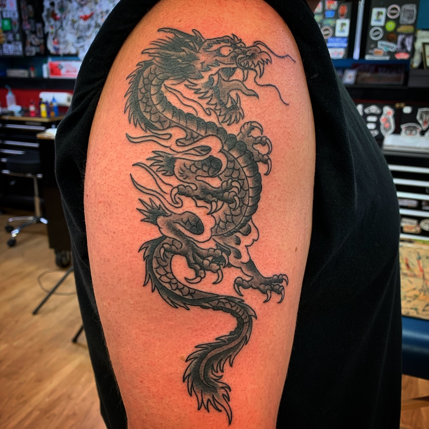 Dragon black and grey tattoo on the upper arm by Tattoos Las Vegas,NV
