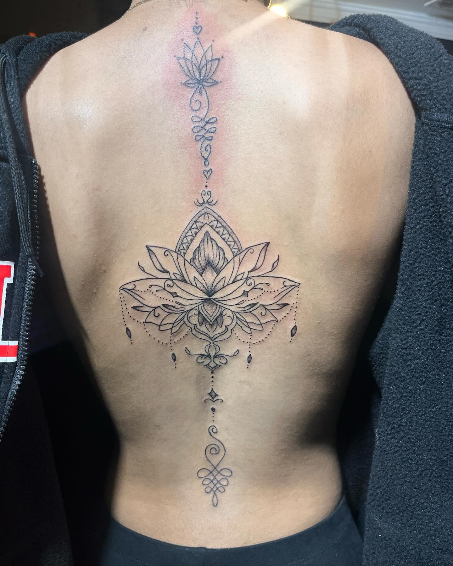 Lotus flower geometric tattoo on the back by Alesia