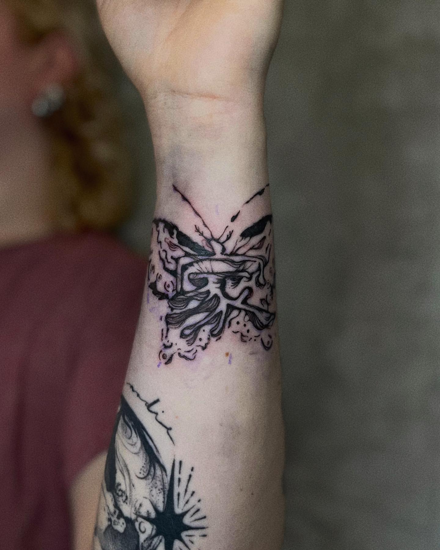 Abstract butterfly black and grey tattoo on the forearm by San Kang