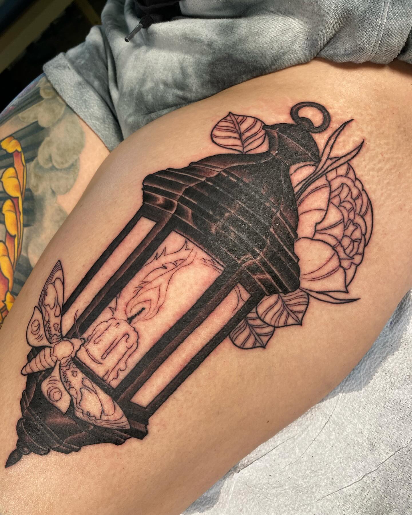 Lantern and floral realism tattoo on the thigh by Eric James, Phoenix, Arizona