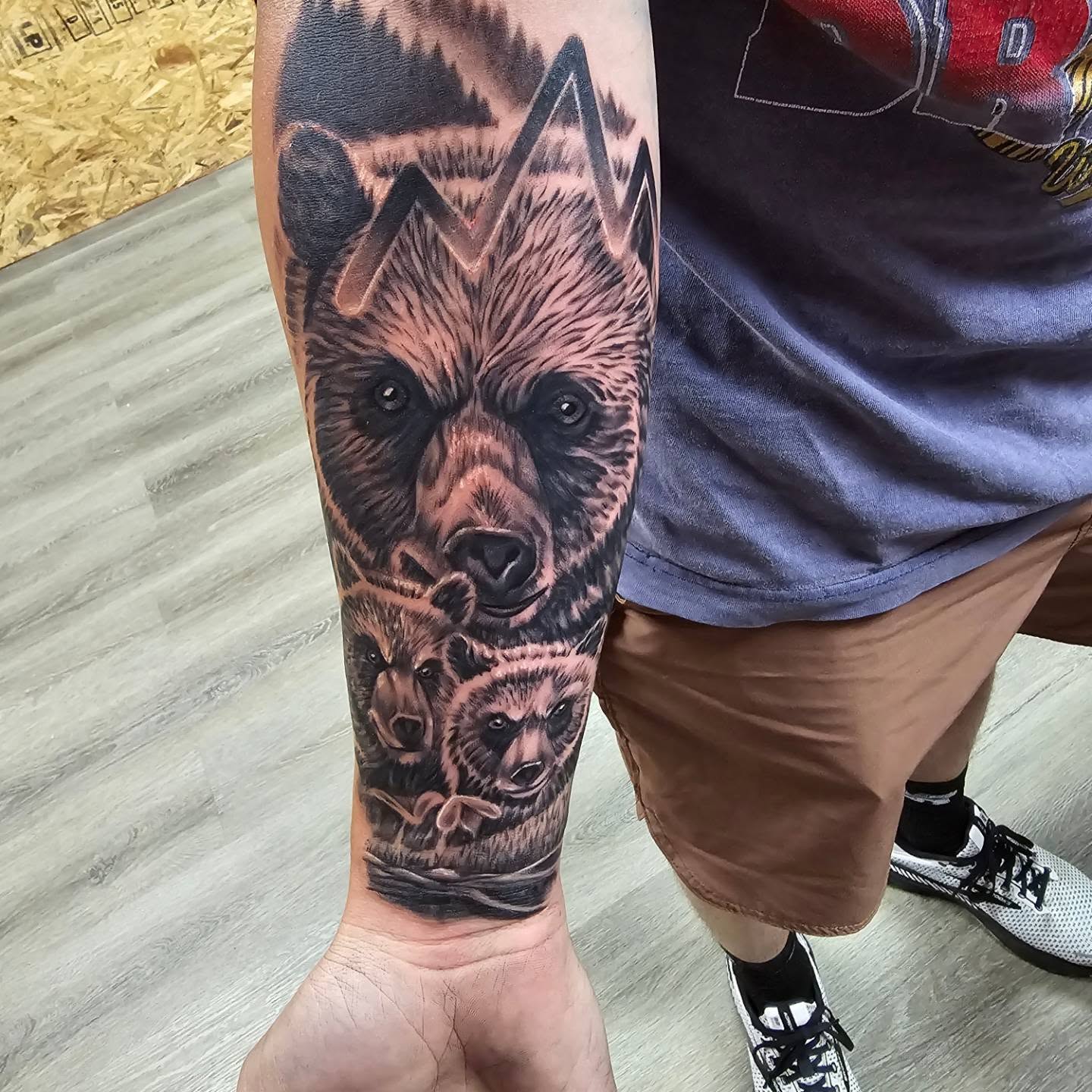 Bear family realism tattoo on the forearm by Gene Britton