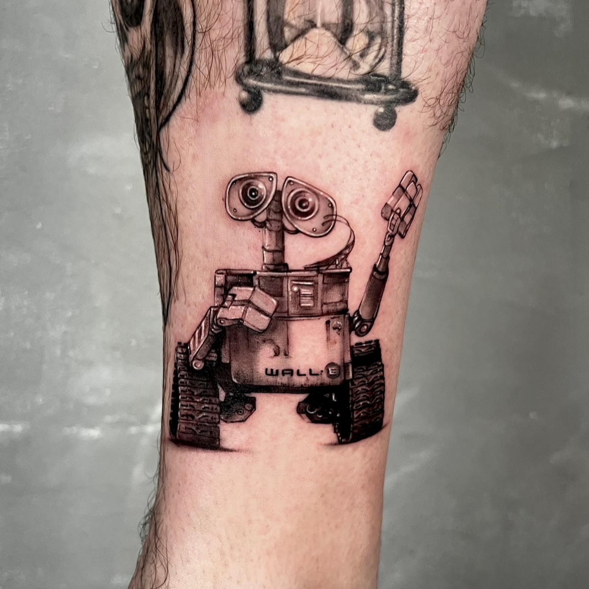 Wall-e black and grey tattoo on the forearm by Milk Tattoos 🇸🇻🇪🇸