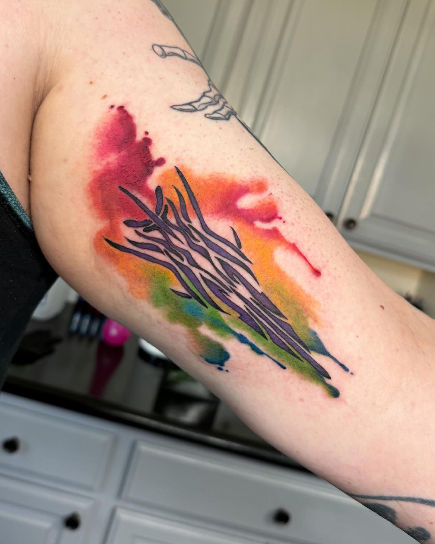 Watercolor splash watercolor tattoo on the forearm by Robyn Mahon