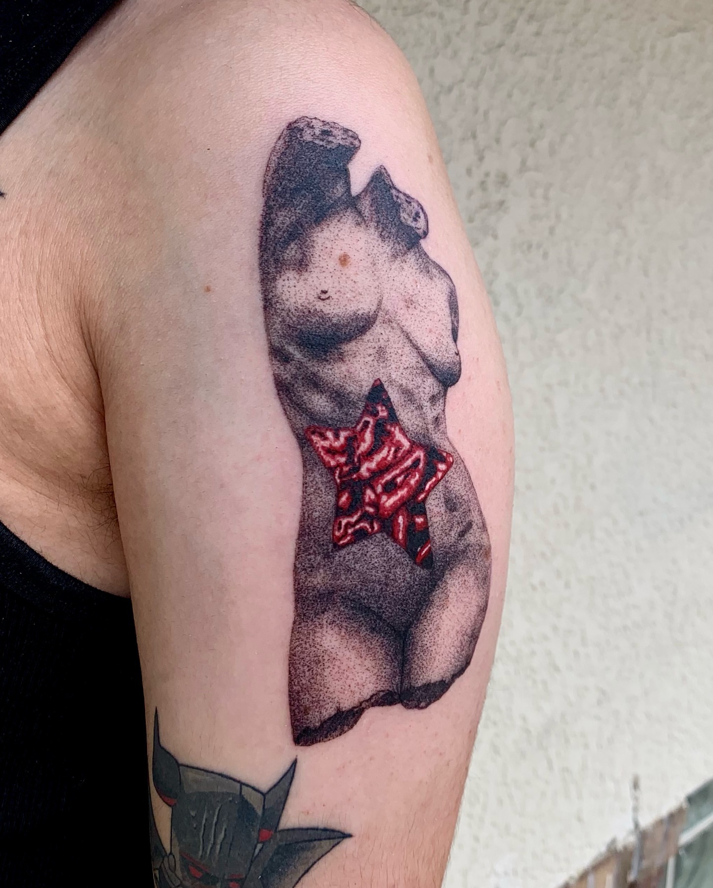 Nude female torso dotwork tattoo on the upper arm by Maddy Paige