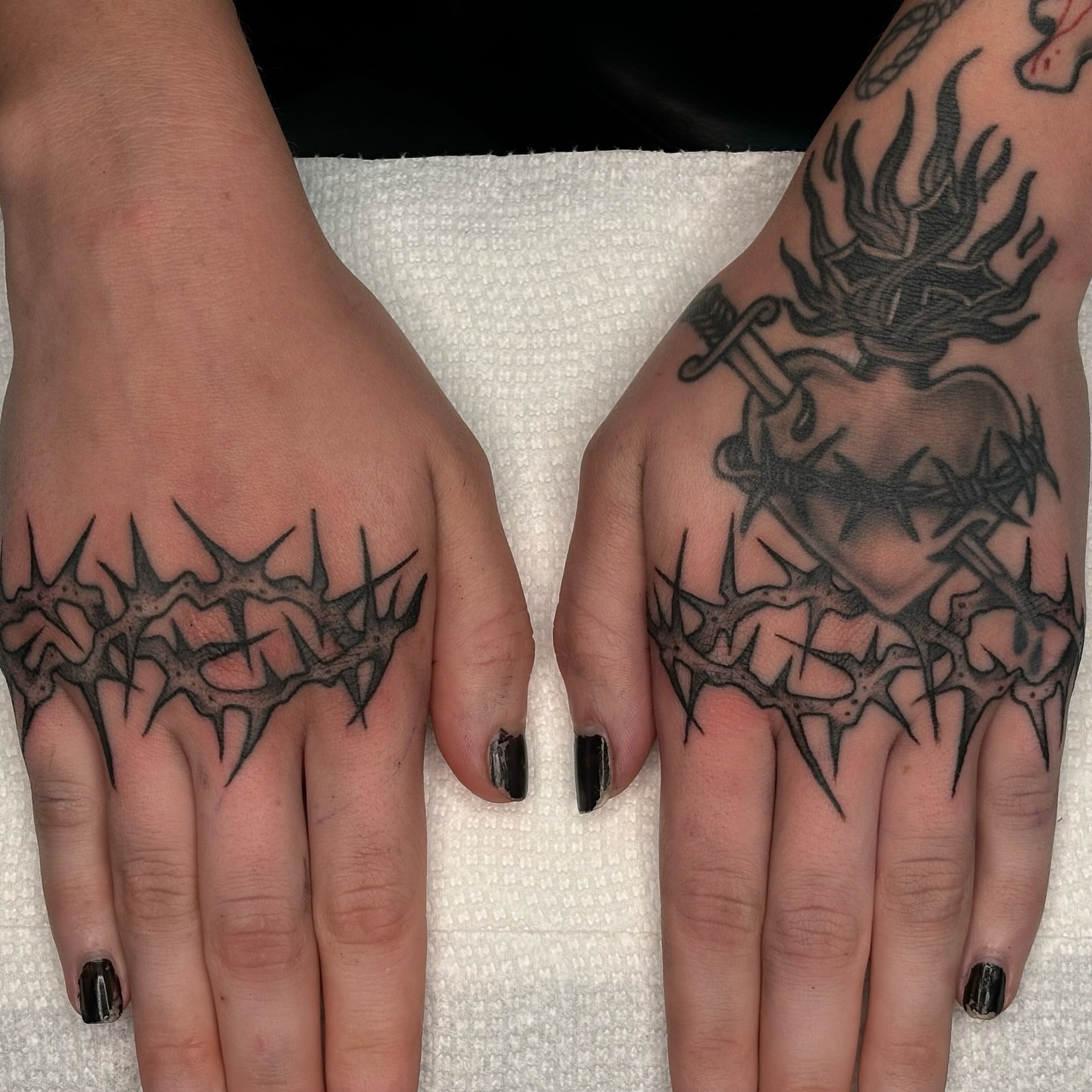Heart with crown of thorns black and grey tattoo on the hand by Jordan Wray