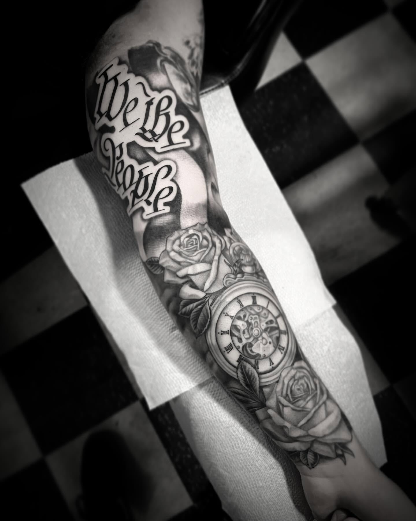 We the people black and grey tattoo on the forearm by Jacob Finelli