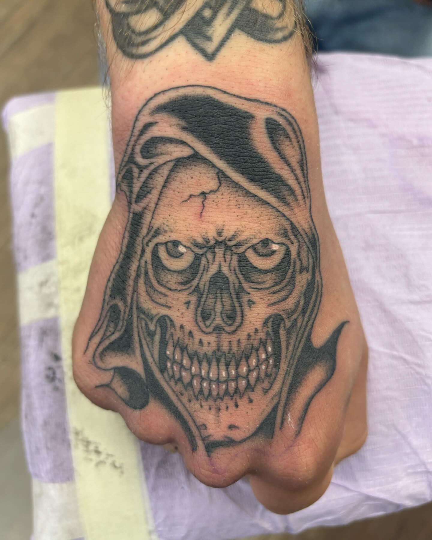 Skull black and grey tattoo on the hand by Brayden P Tattoo