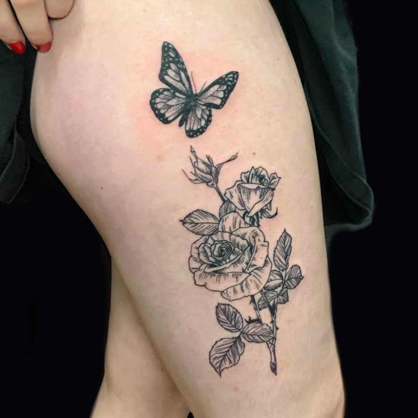 Butterfly and roses black and grey tattoo on the thigh by Bryan Black