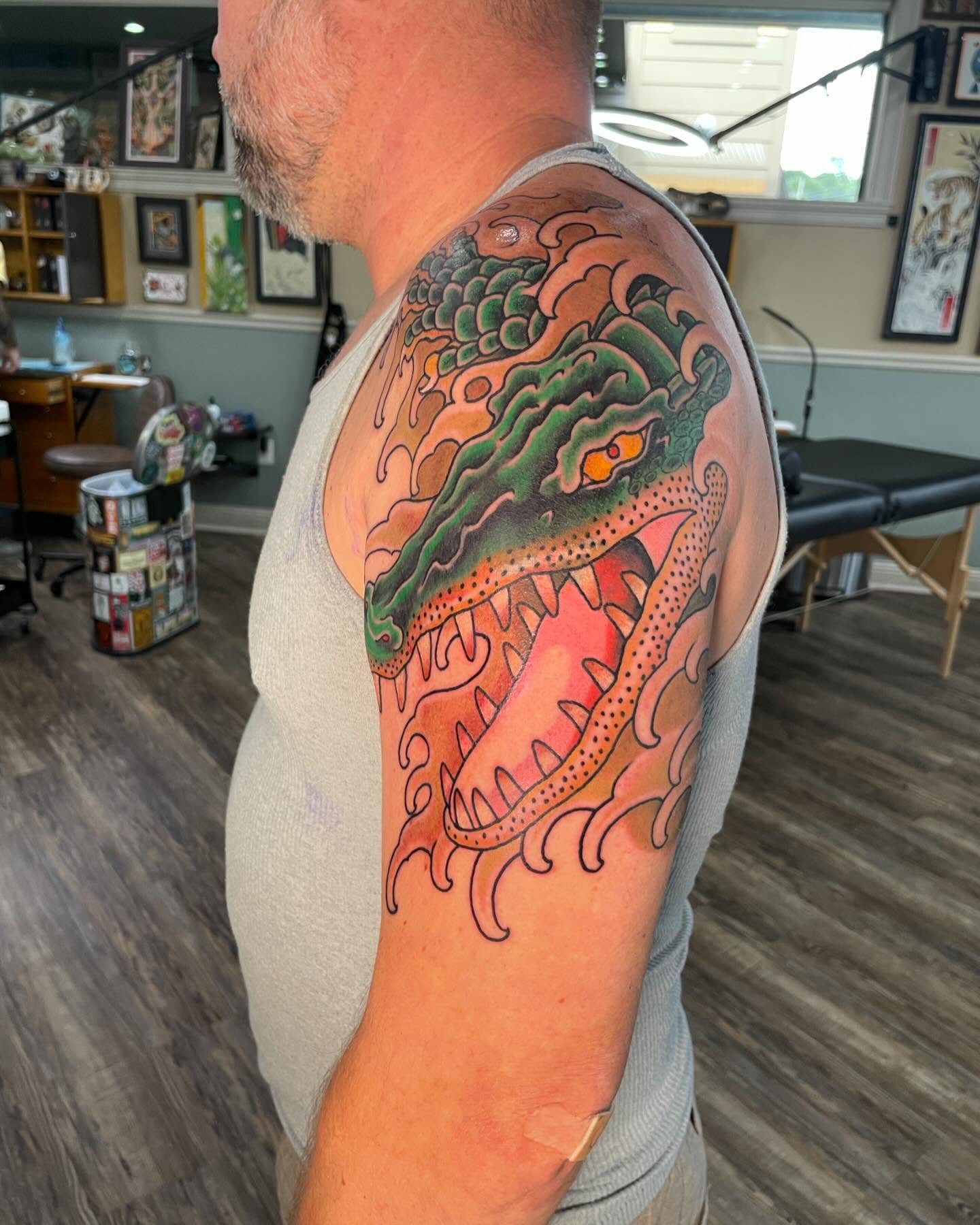Alligator American traditional tattoo on the upper arm by Caleb Baker