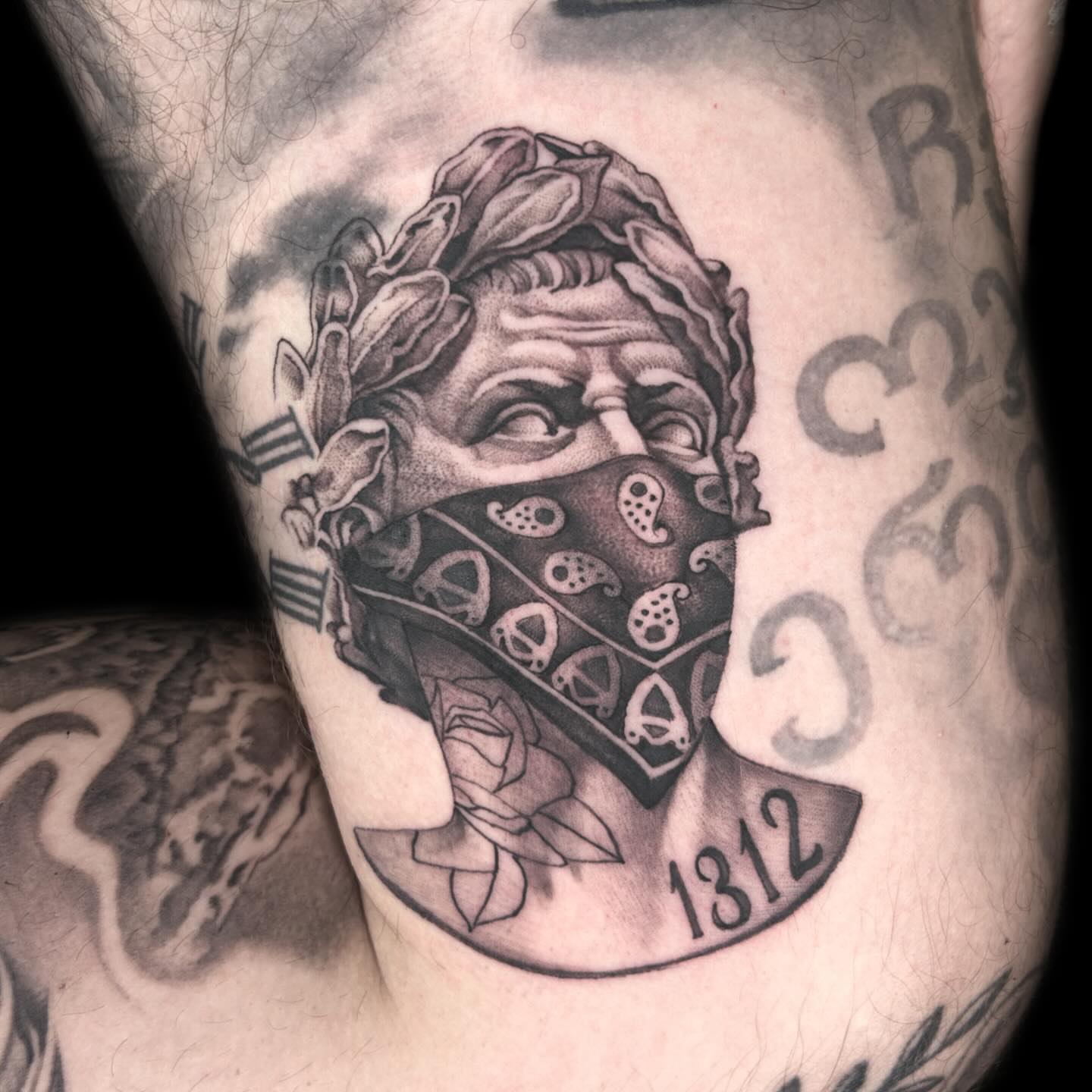 Bandana-wearing man realism tattoo on the thigh by Ryan Futterman