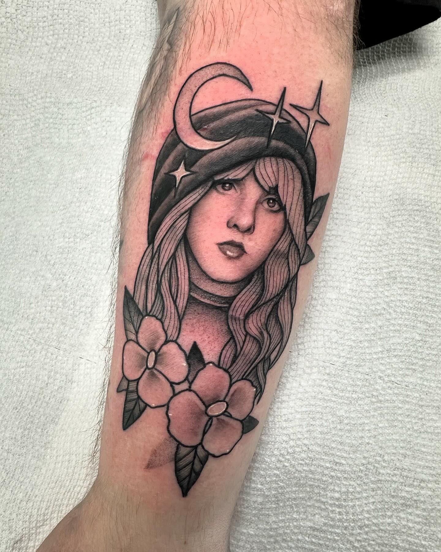 Girl with flowers realism tattoo on the forearm by Lawrence Edwards