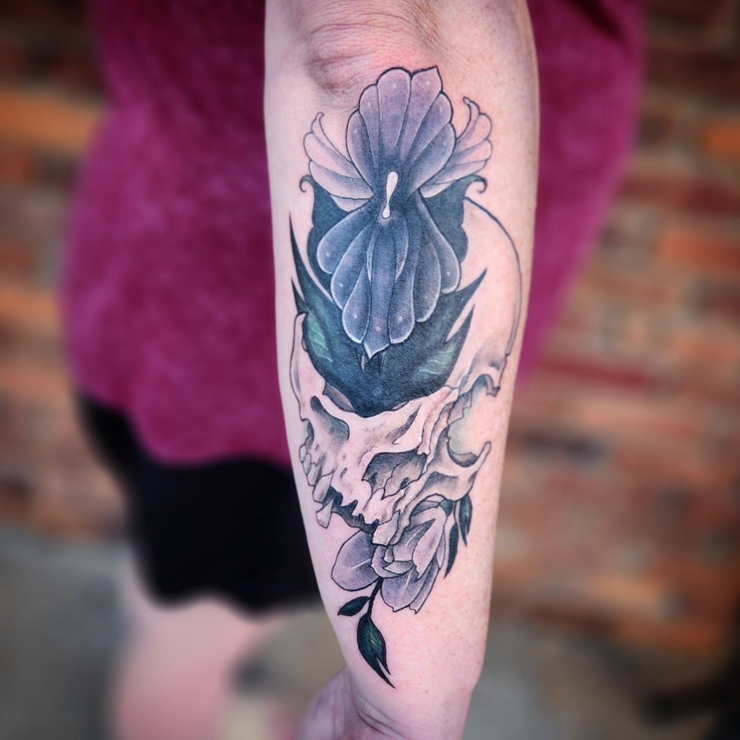 Skull and flower American traditional tattoo on the forearm by Jennalea