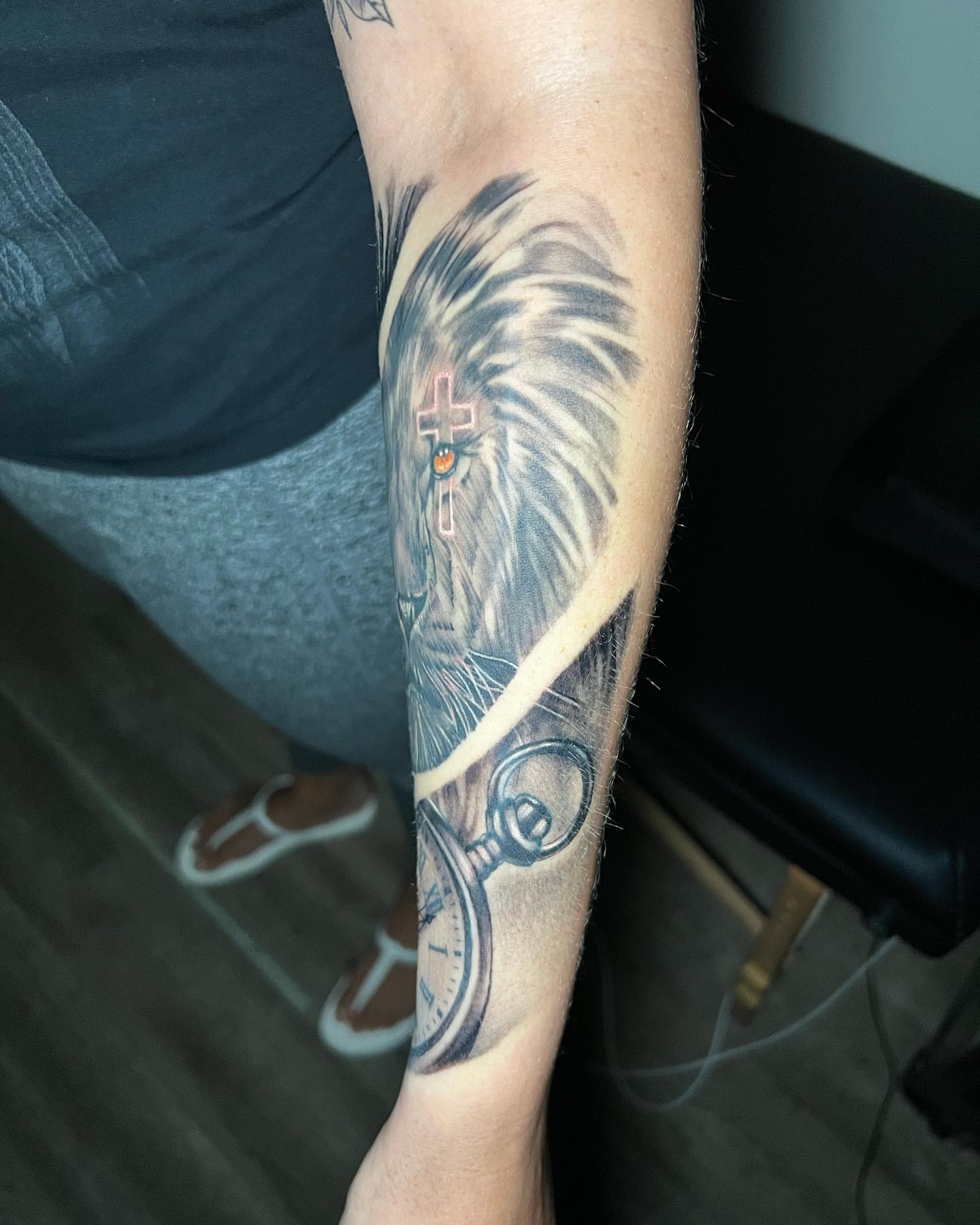 Lion with cross realism tattoo on the forearm by Matthew Arguello