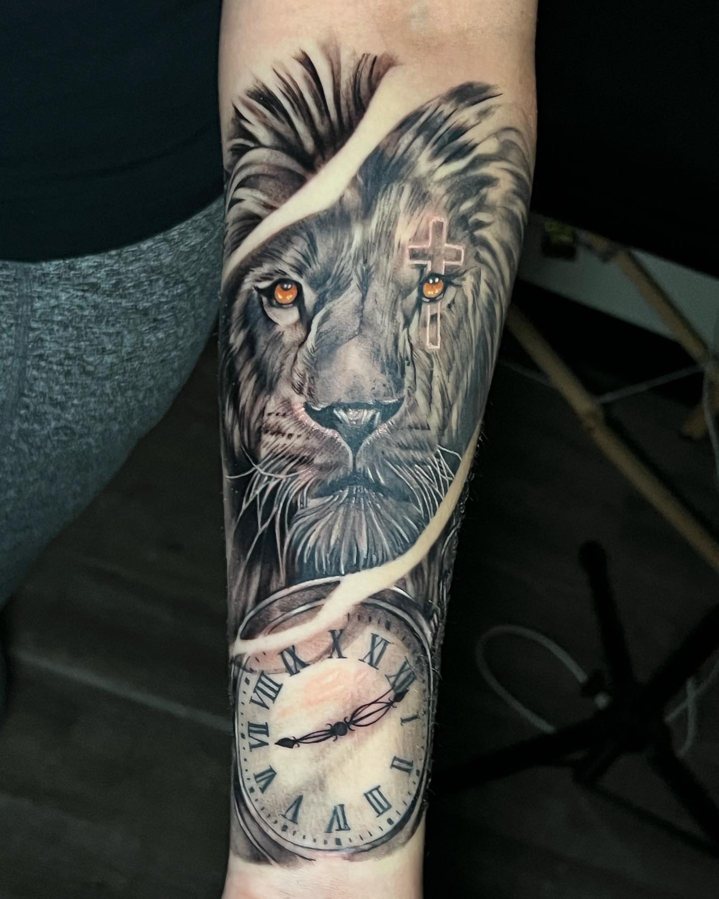 Lion and clock realism tattoo on the forearm by Matthew Arguello