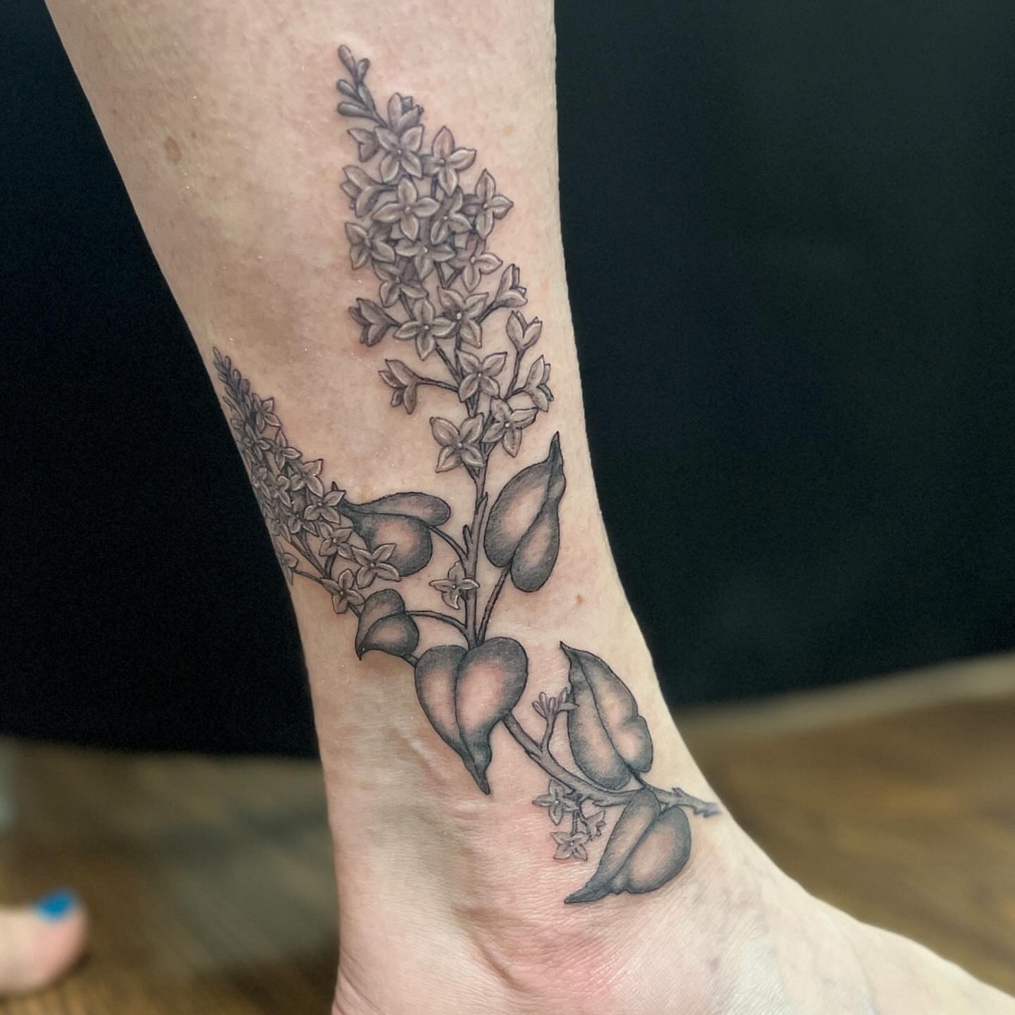 Flower and pod black and grey tattoo on the foot by Hildur Blom, Seattle, Washington