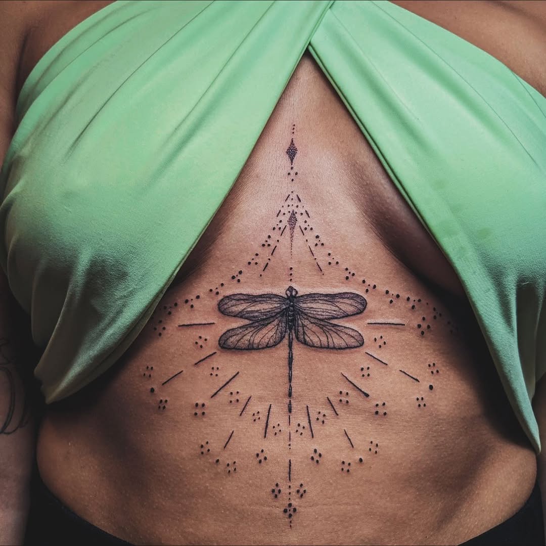 Dragonfly with geometric patterns fine line tattoo on the ribs by Aim 🤍