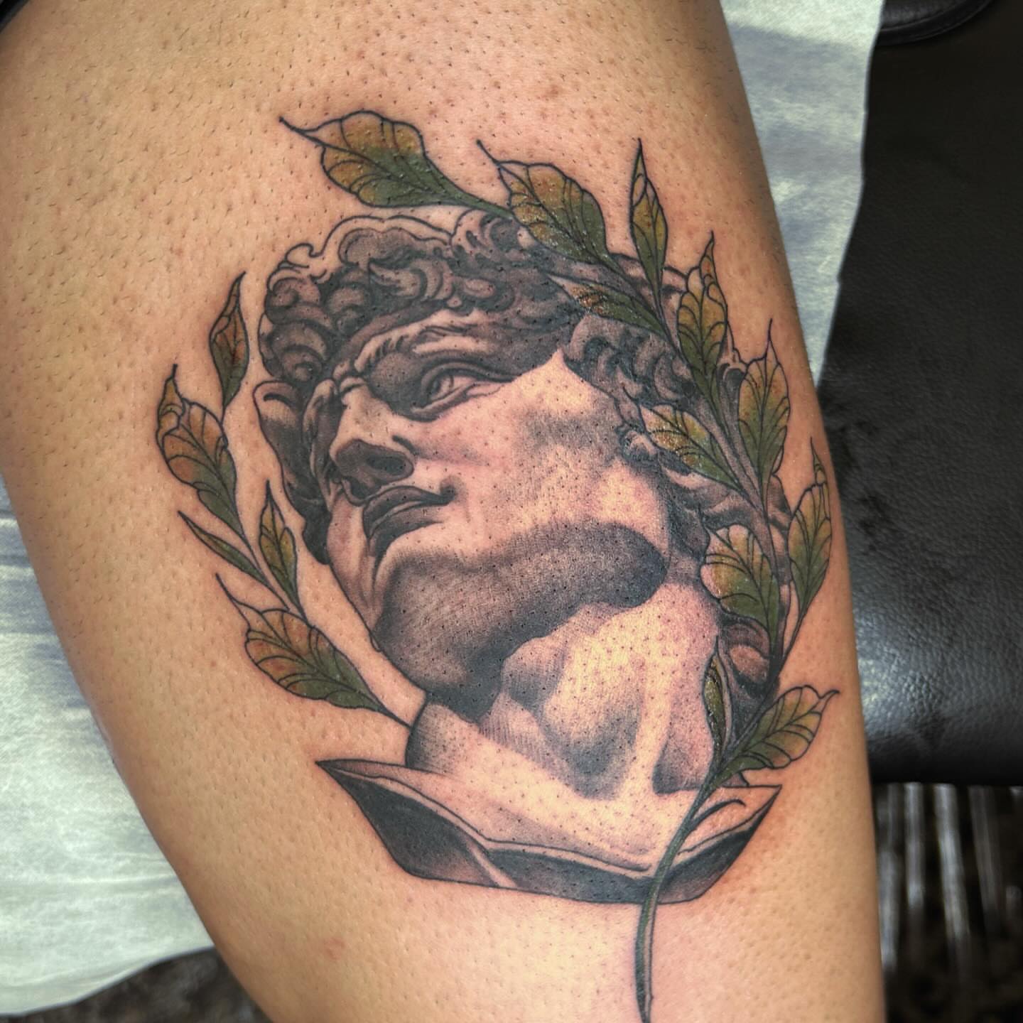 Statue head realism tattoo on the thigh by Ryan Futterman