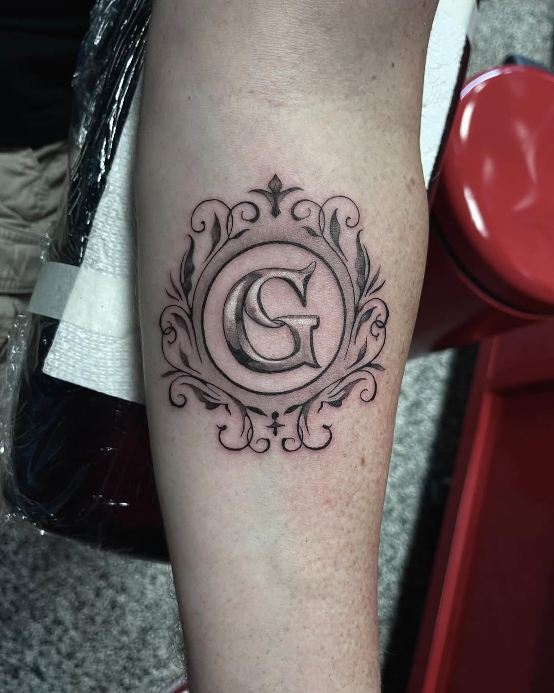 Letter G in ornate frame tribal tattoo on the forearm by Jonathan Red