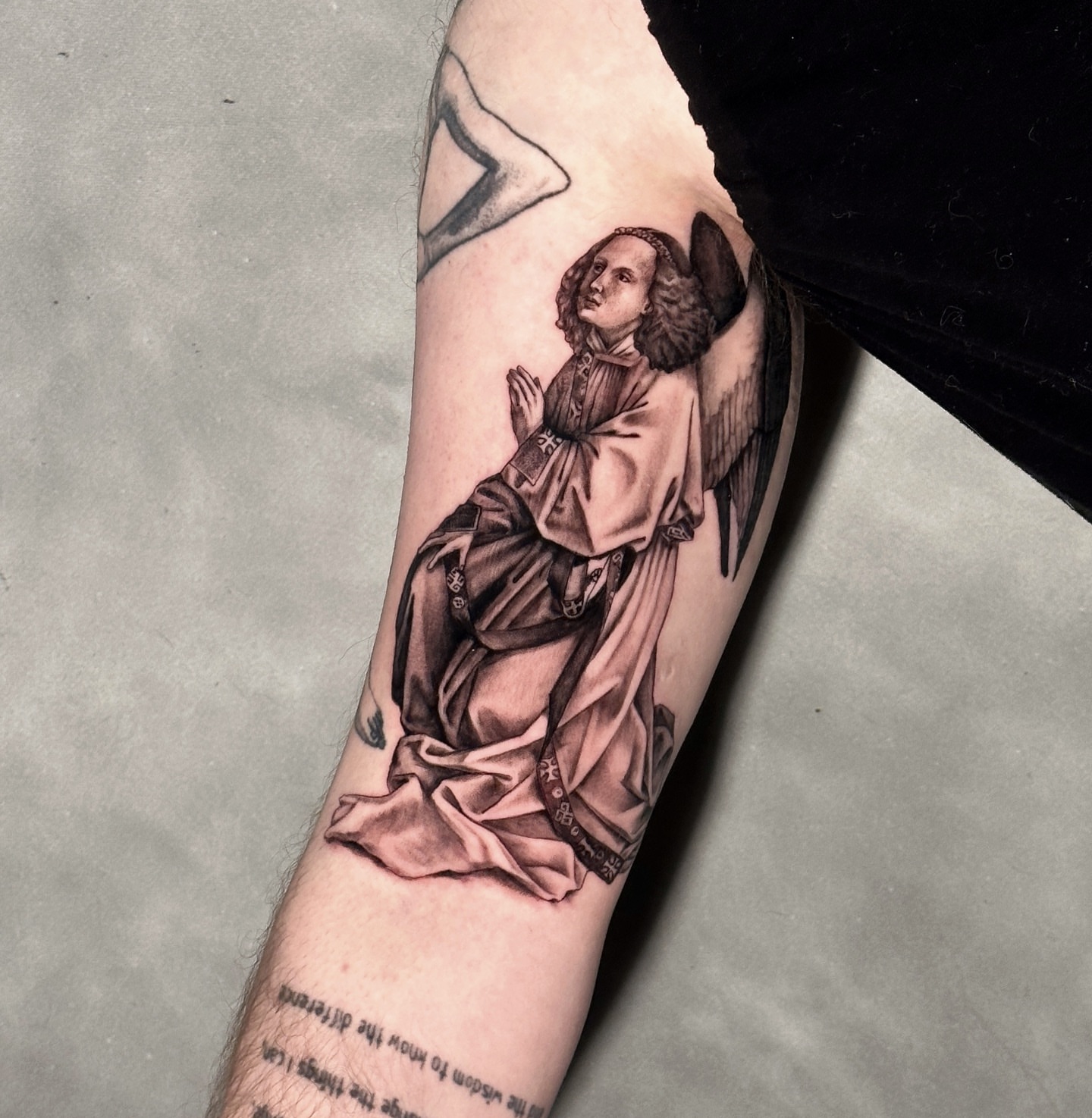 Angel praying realism tattoo on the forearm by Madeleine Fleming