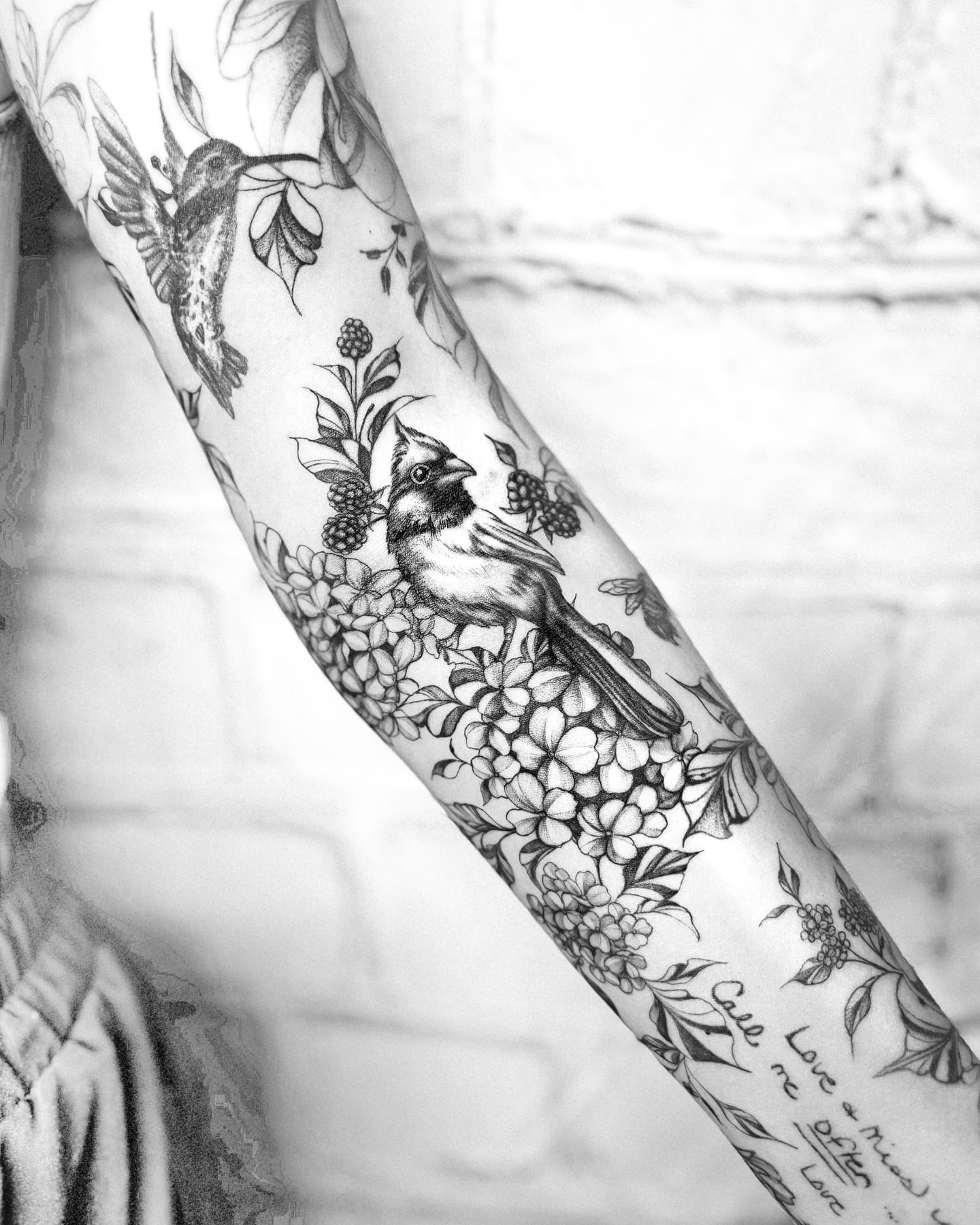 Bird and floral realism tattoo on the forearm by Ayauna Mai