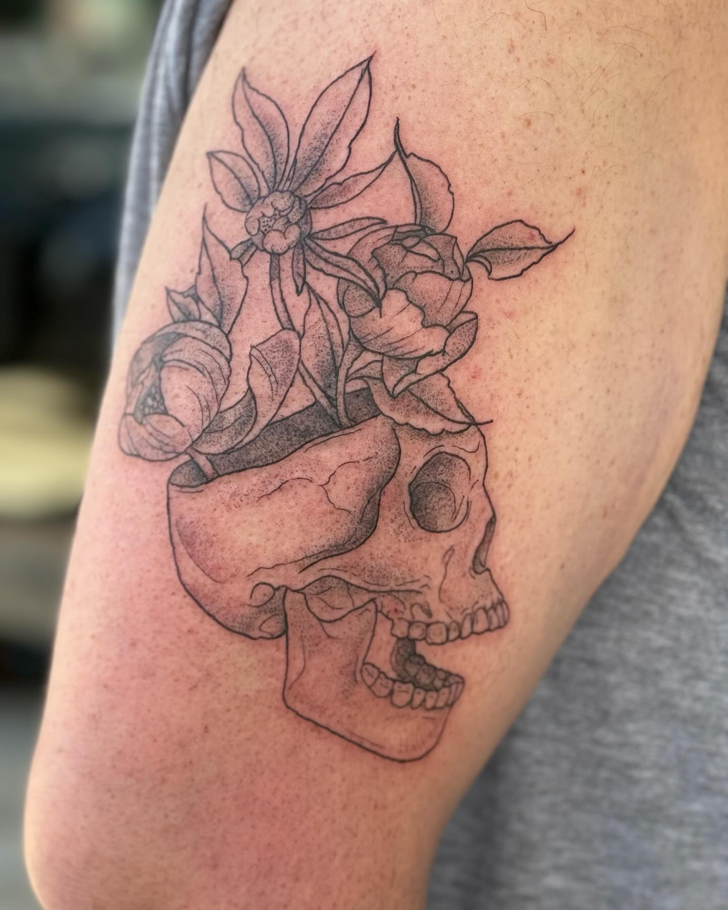 Skull and flowers dotwork tattoo on the forearm by Marissa Losier