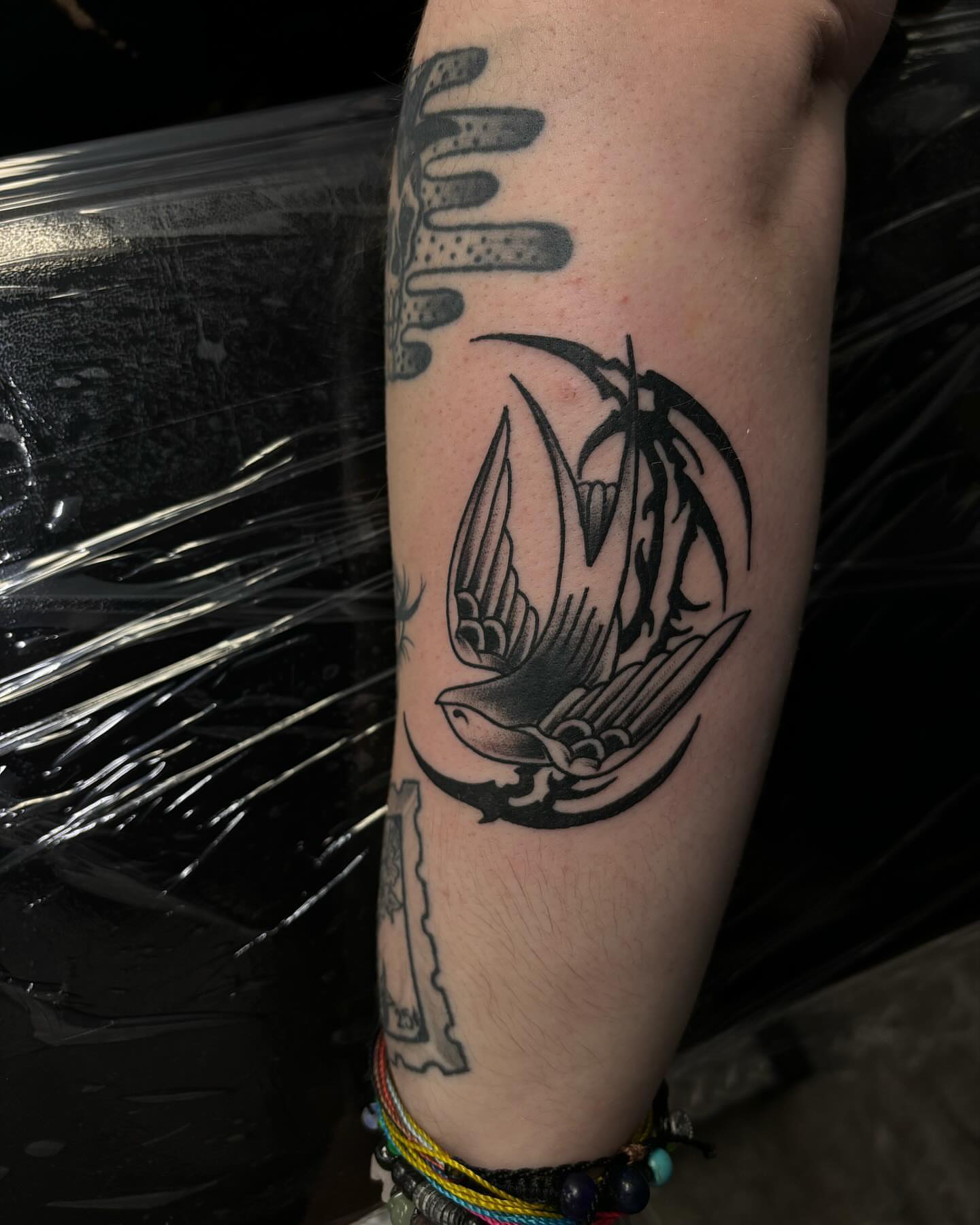 Swallow and palm tree black and grey tattoo on the forearm by Ares Rhodes