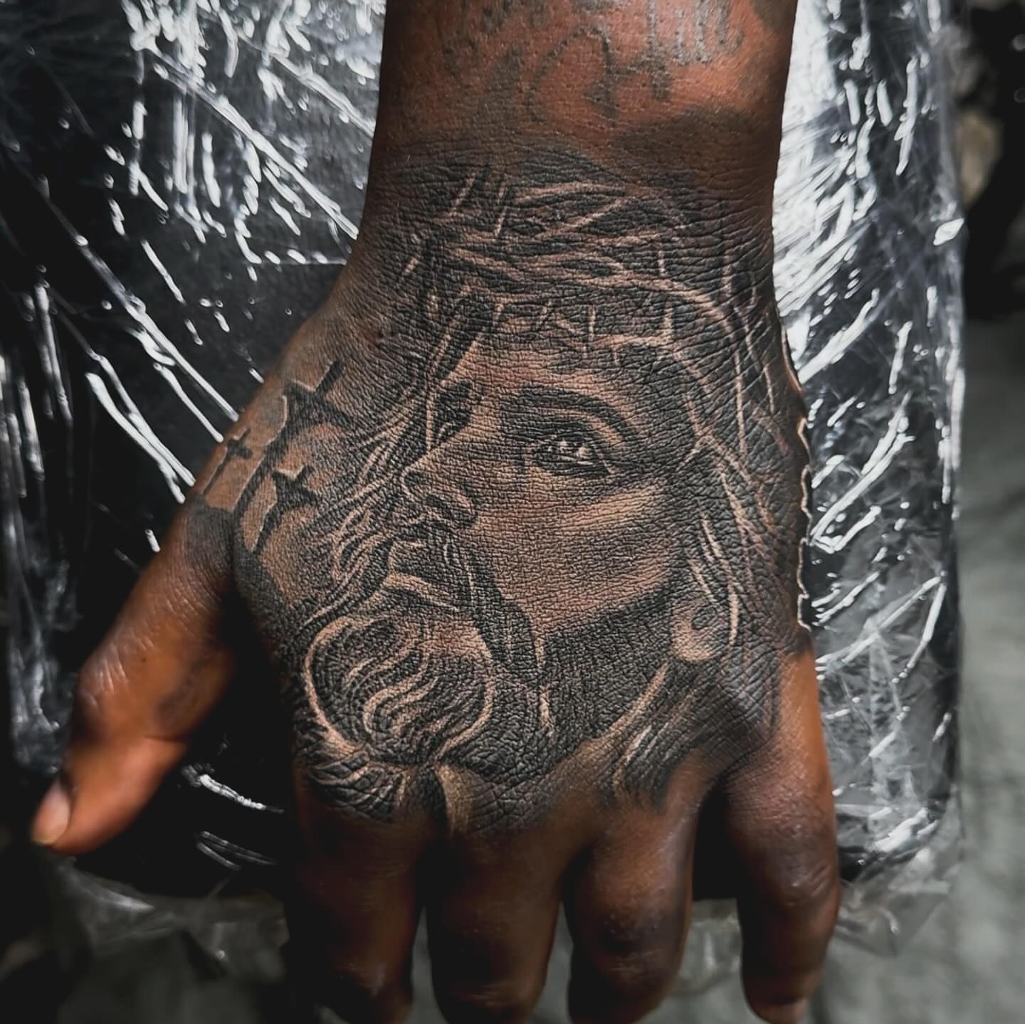 Religious figure black and grey tattoo on the hand by Tatt2T (T King)