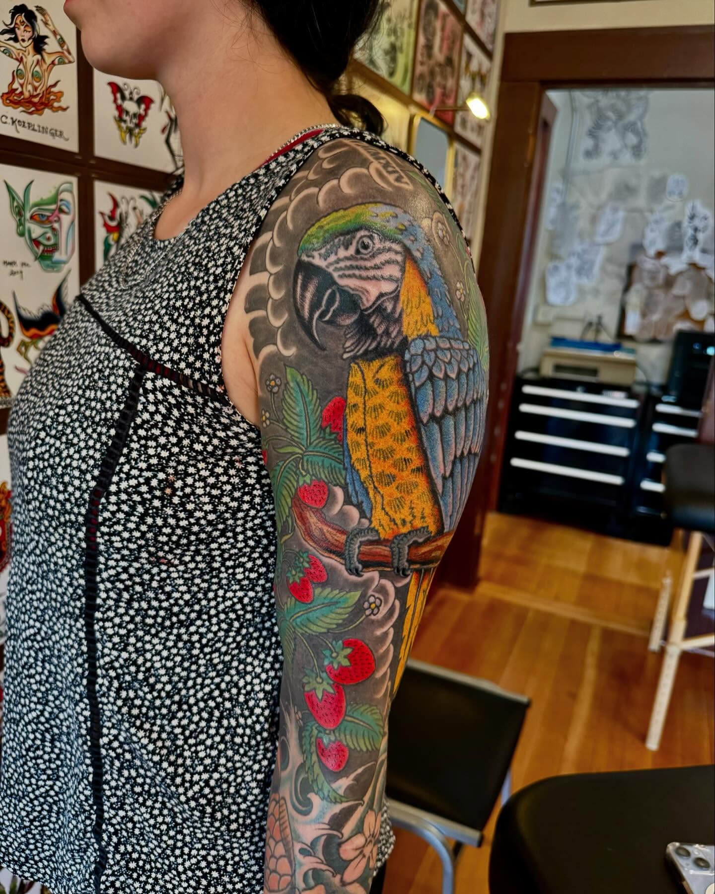 Parrot and strawberries American traditional tattoo on the forearm by Nick Rodin