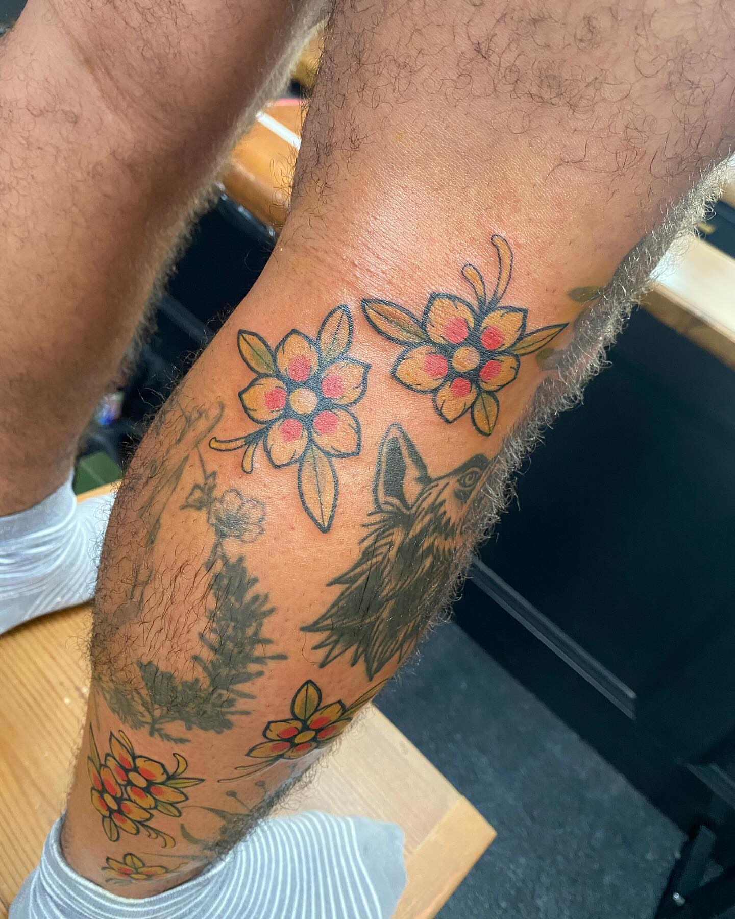Wolf and flowers American traditional tattoo on the forearm by S C O T T