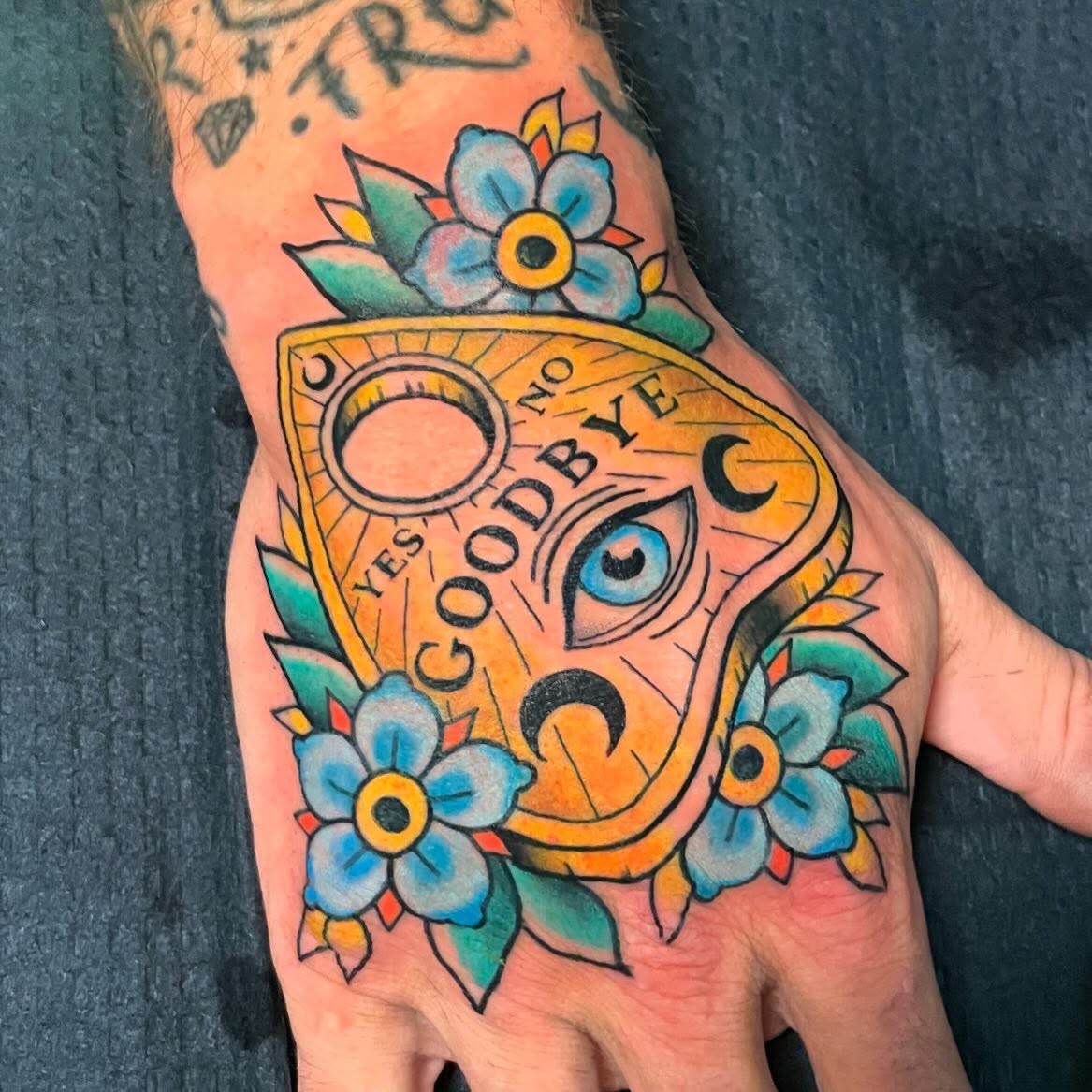 Spirit board American traditional tattoo on the hand by Candence Smith