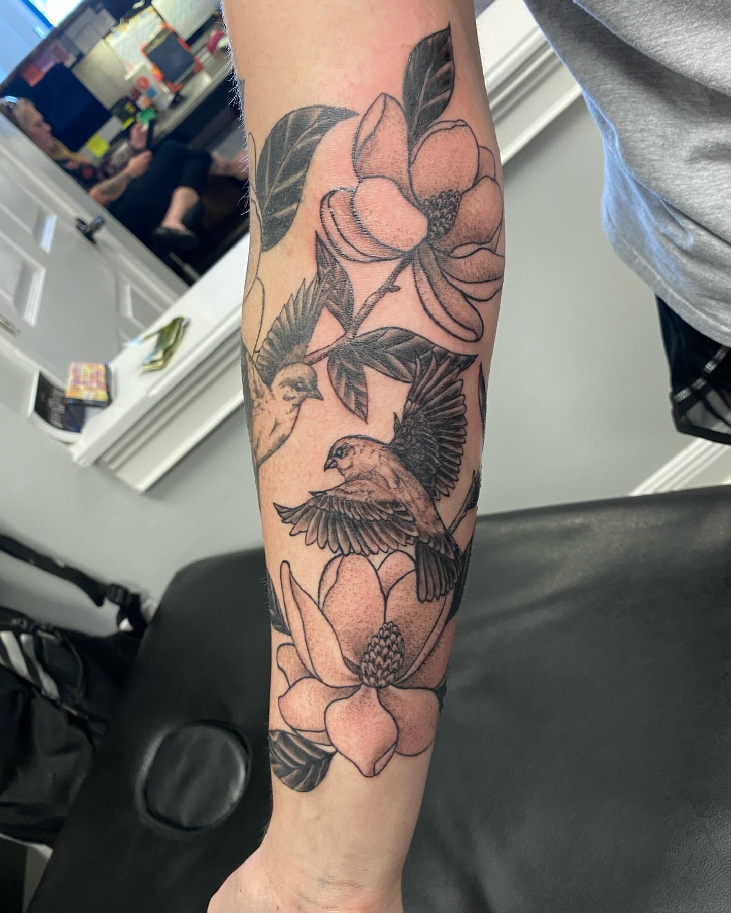 Magnolia and birds black and grey tattoo on the forearm by Missy (Miz)