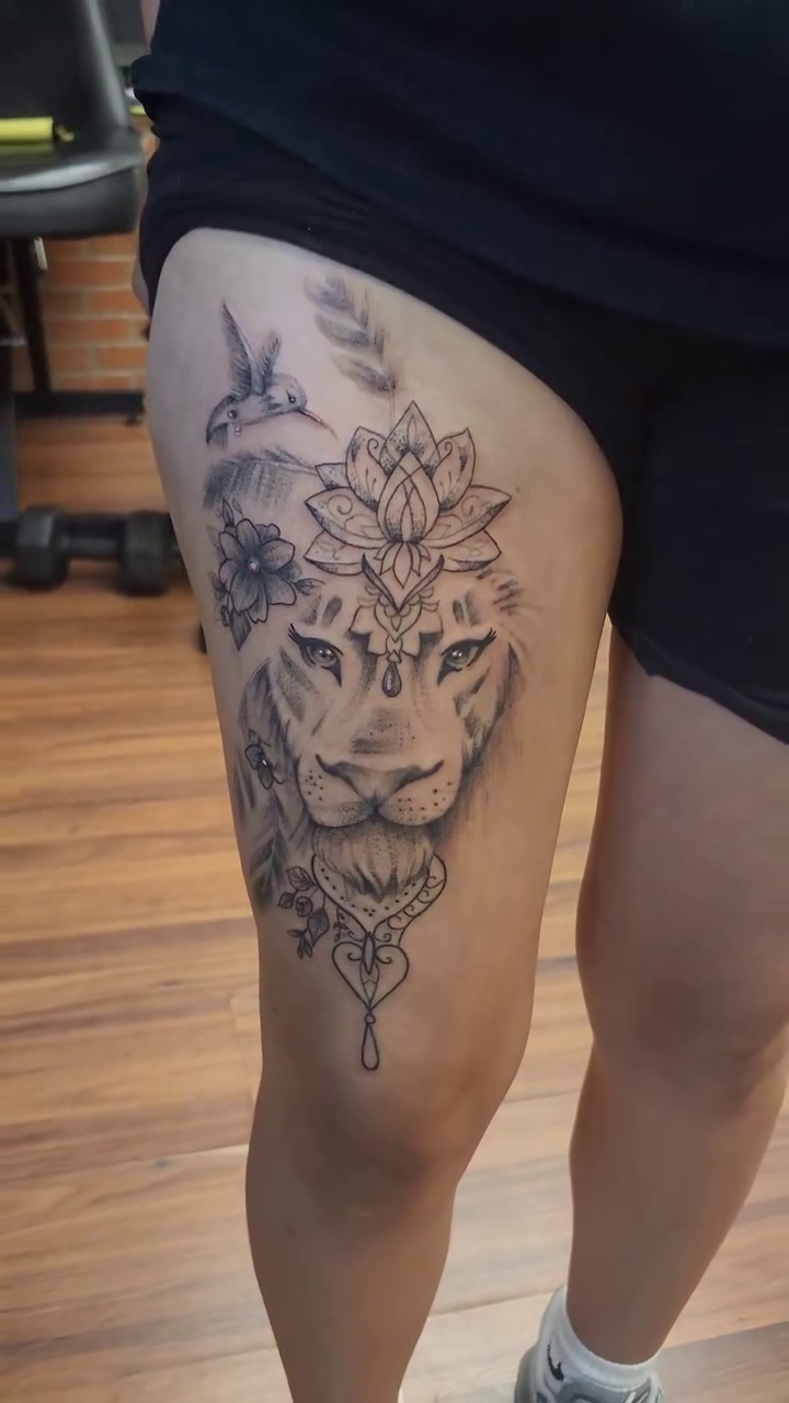 Lion head with lotus and hummingbirds fine line tattoo by Marvin Osorno