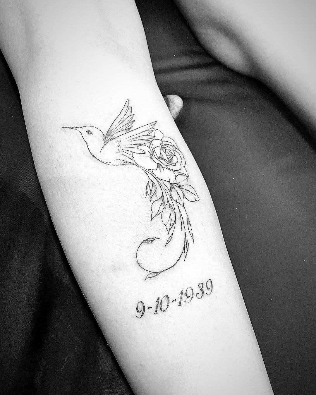 Hummingbird and rose with date tattoo on the forearm by Bear