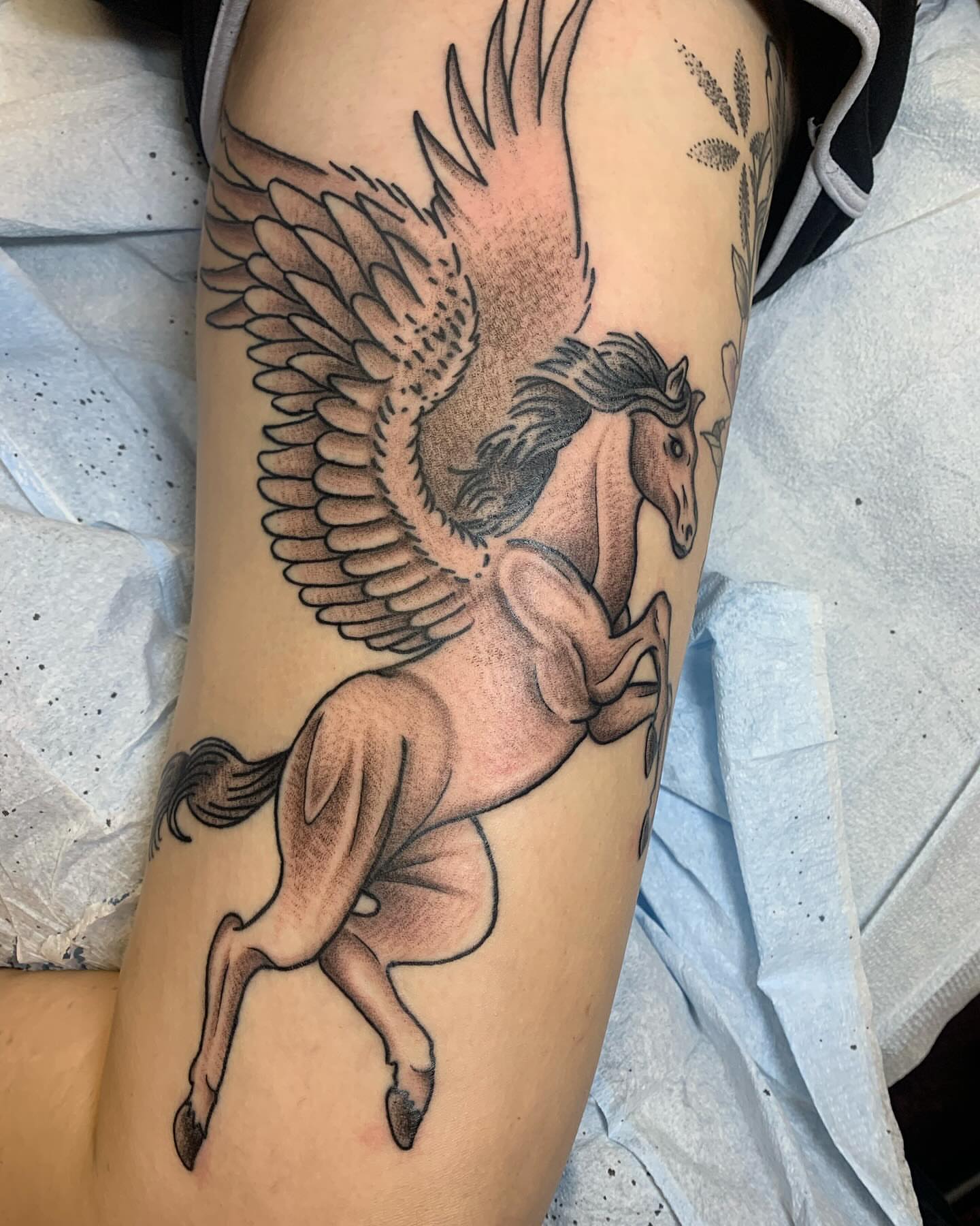 Pegasus black and grey tattoo on the thigh by Cody Marl