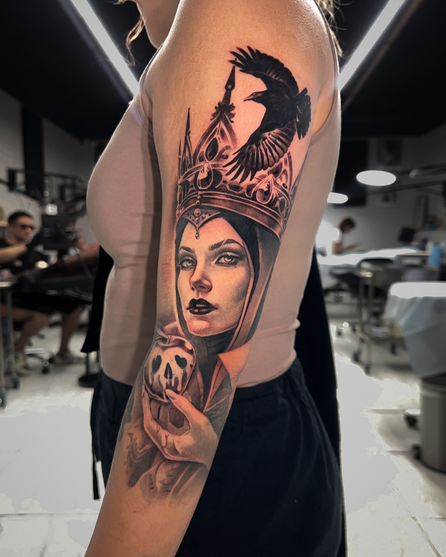 Woman wearing crown realism tattoo on the upper arm by Joey Hella Tattoo Artist