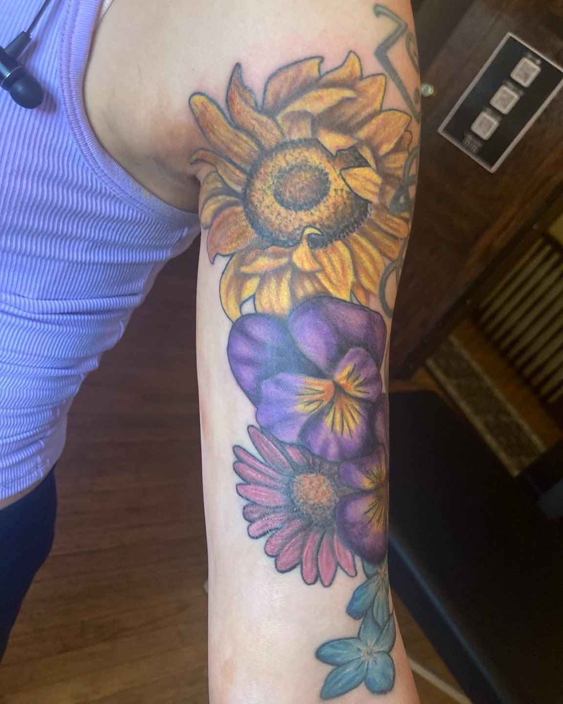 Sunflowers and pansies realism tattoo on the forearm by Madeline, Akron, Ohio