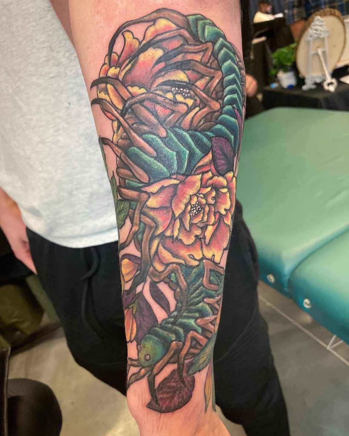 Scorpion and flowers new school tattoo on the forearm by Madeline, Akron, Ohio