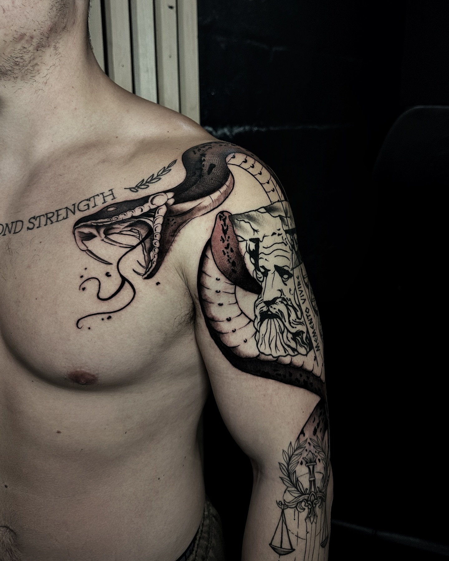 Snake and bust realism tattoo on the shoulder by Alejo Ibanez Tattoo