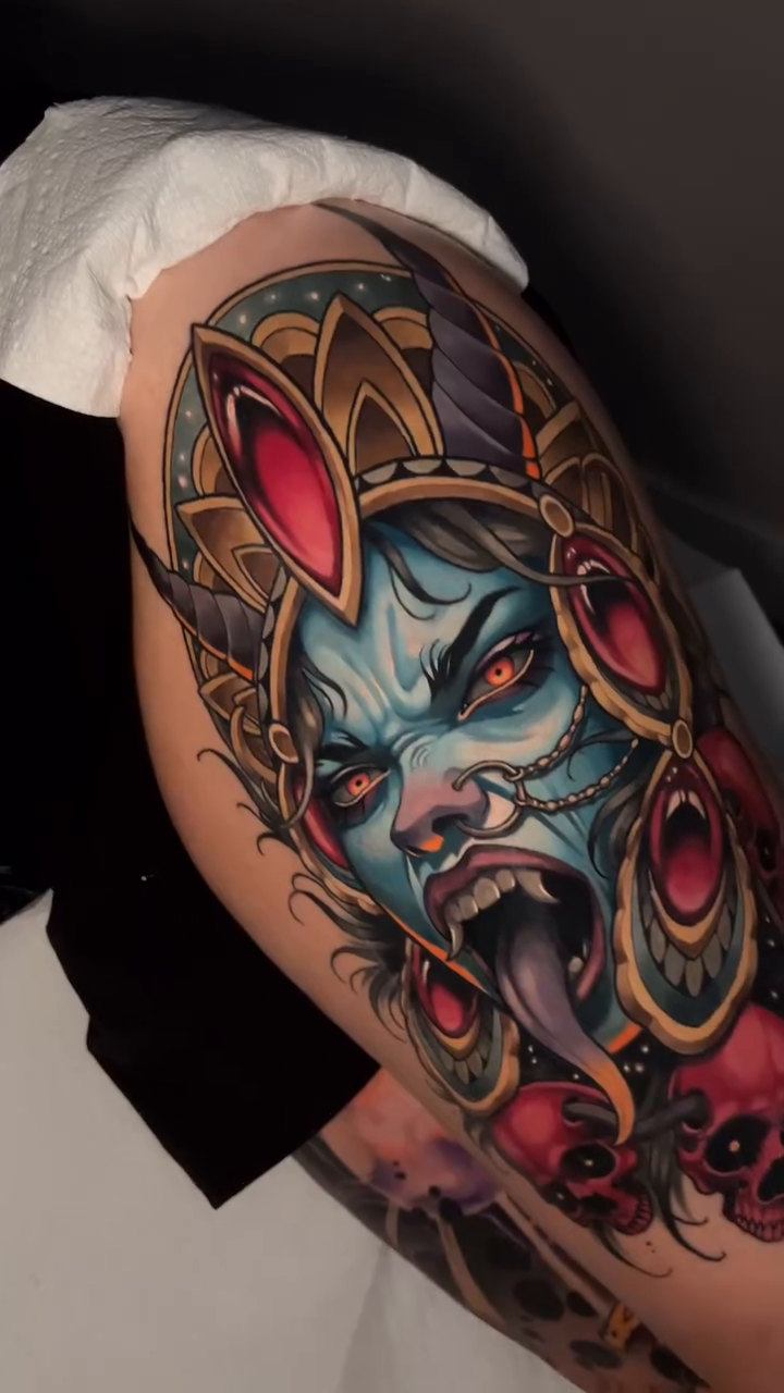 Demonic goddess with skulls neo-traditional tattoo on the upper arm by Andrey