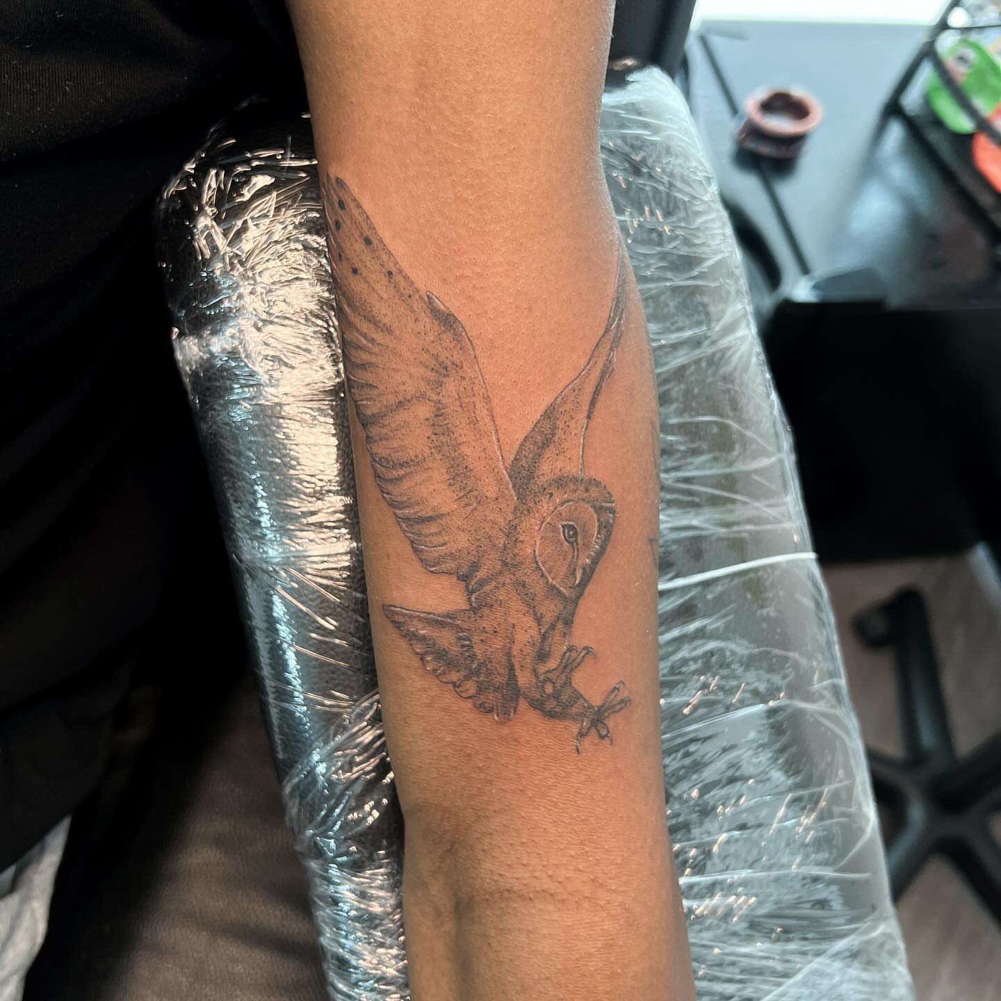 Owl black and grey tattoo on the forearm by Syd Cheyenne