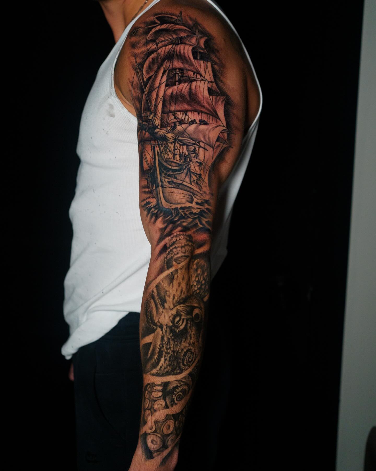 Ship and sea monster realism tattoo on the upper arm by Nate Masi