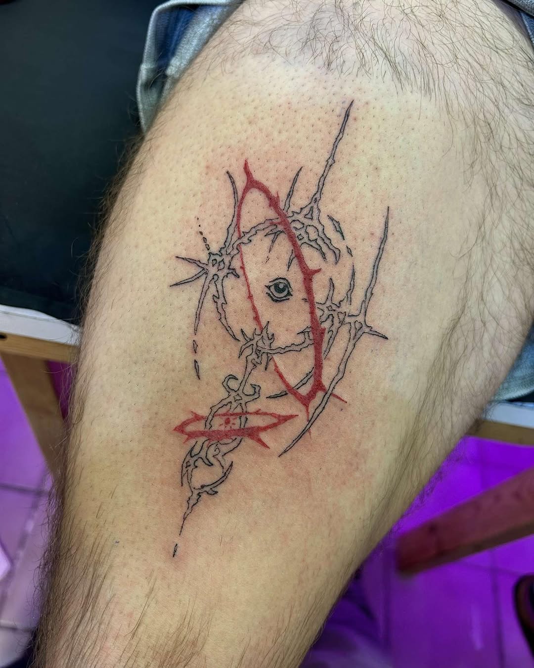 Abstract eye with thorns blackwork tattoo on the thigh by Bear