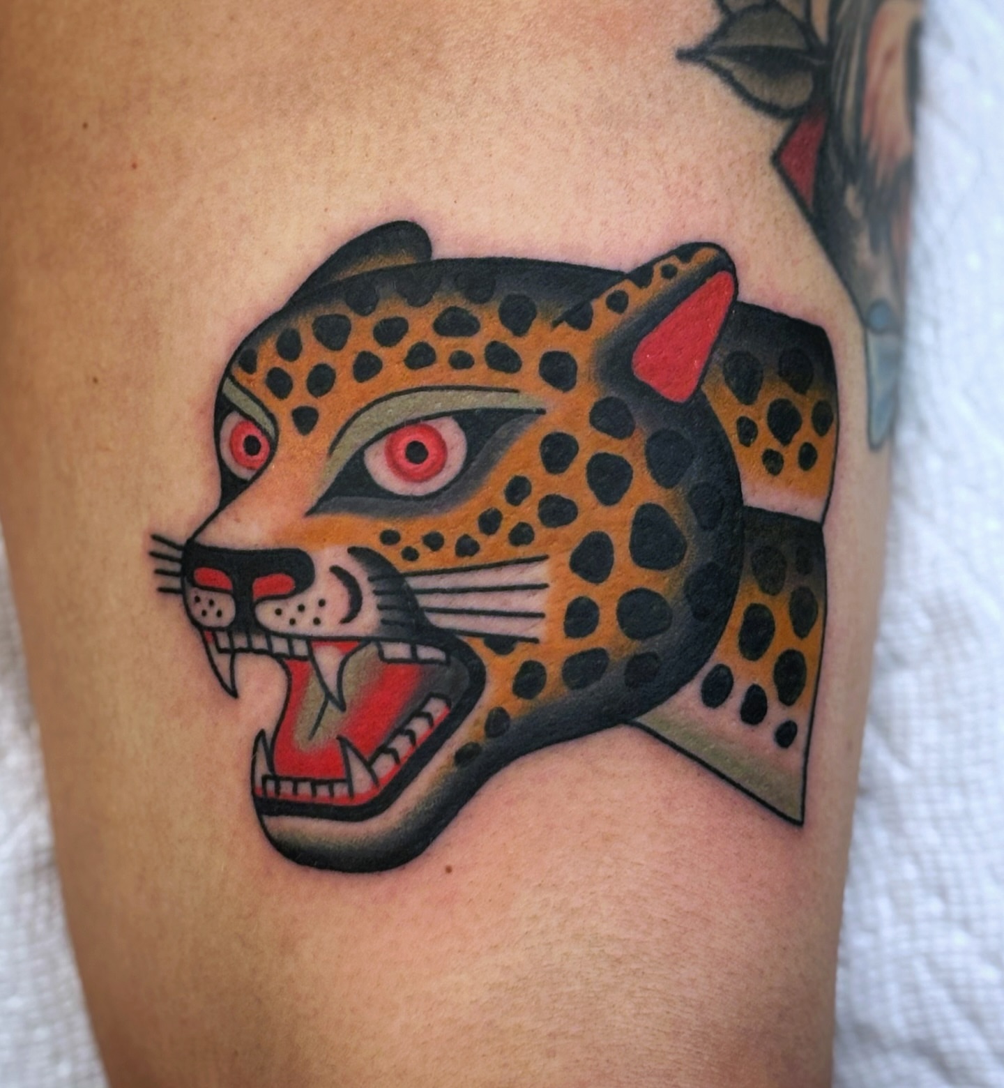 Jaguar head American traditional tattoo on the thigh by Ben Fiedler