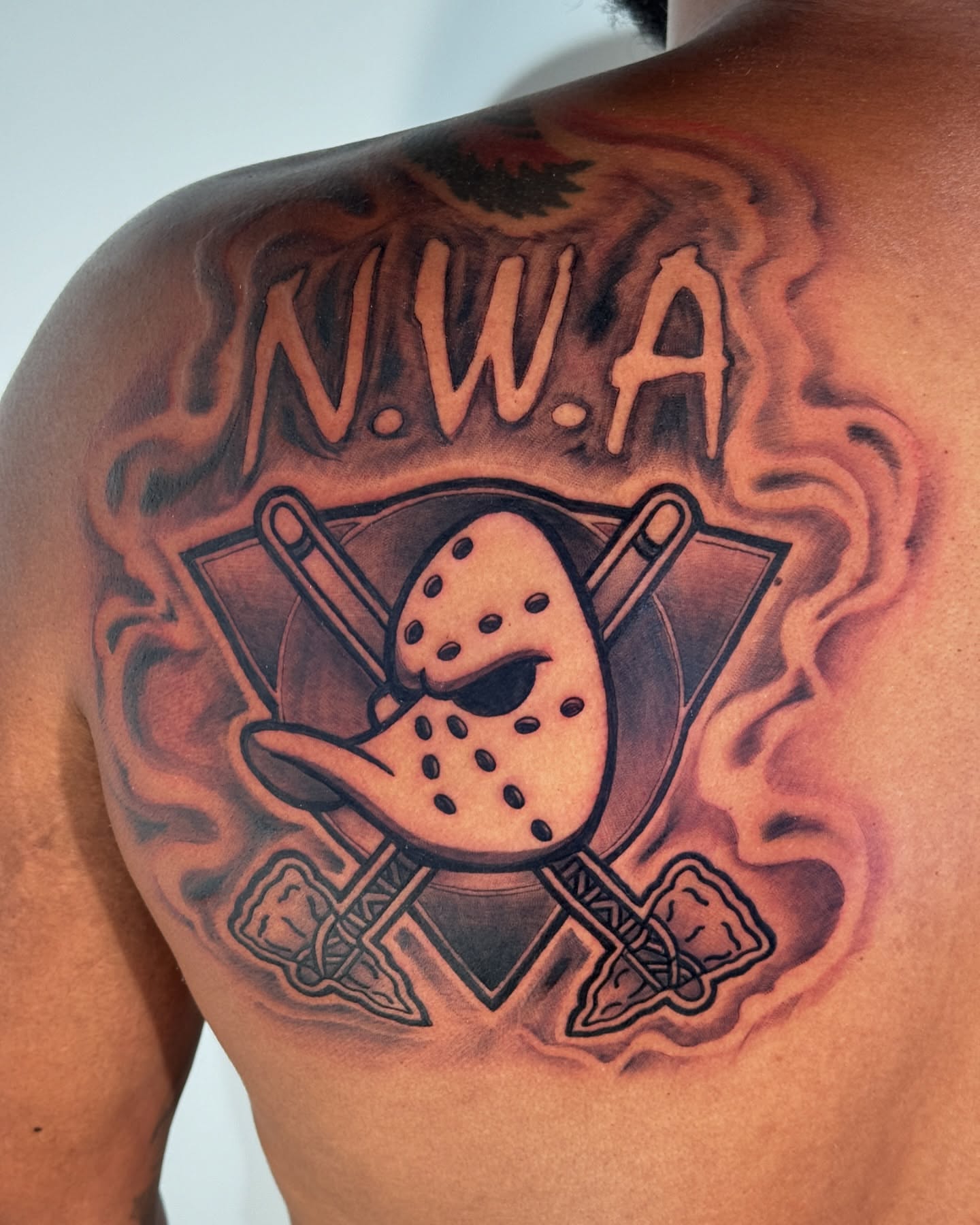 N.W.A. mask and hockey sticks trash polka tattoo on the shoulder by Paul Jack II ⚜️ Tattoo Artist ⚜️Atlanta