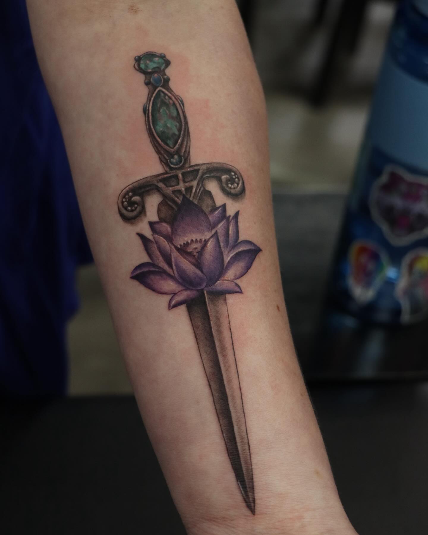 Lotus flower and sword realism tattoo on the forearm by Alex Suarez